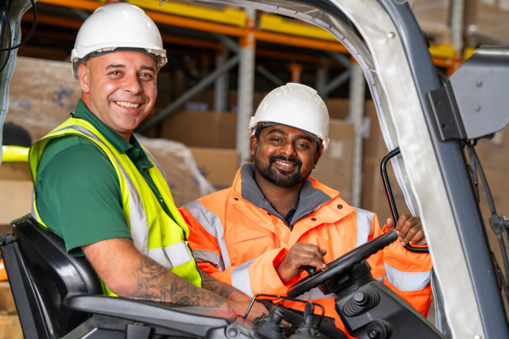 Two smiling workers wearing Centurion safety protective helmets.